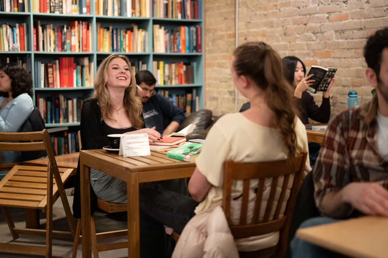 Attendees laughing and talking together at a café table